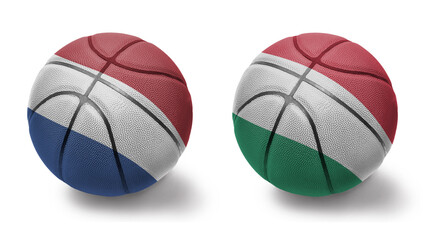 basketball balls with the national flags of hungary and netherlands on the white background.