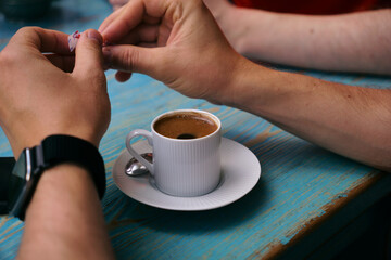 a man adds sugar to a cup of coffee . Morning coffee for breakfast