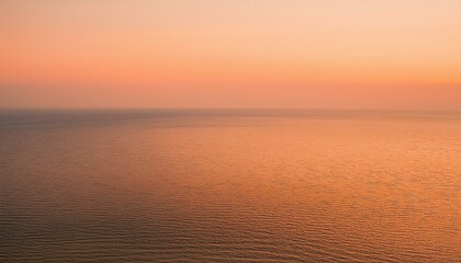 Fototapeta premium A serene ocean scene with a soft, pink sunset sky reflecting on the water.