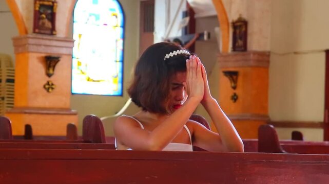 young girl praying at church kneeling at church pew in thoughtful contemplation