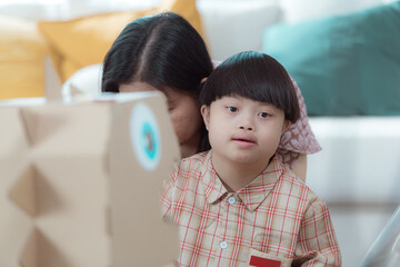 A special child and his mom having fun and relaxing on a holiday together in the living room of the house