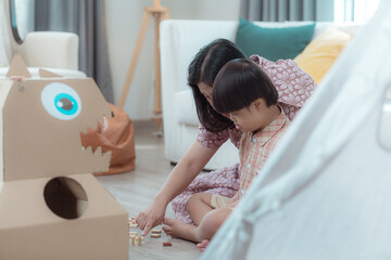 A special child and his mom having fun and relaxing on a holiday together in the living room of the house