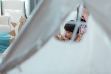 A special child and his mom having fun and relaxing on a holiday together in the living room of the house