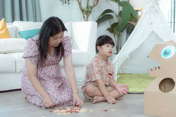 A special child and his mom having fun and relaxing on a holiday together in the living room of the house