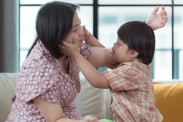 A special child and his mom having fun and relaxing on a holiday together in the living room of the house