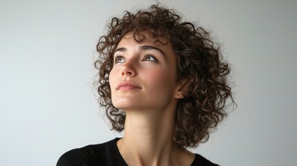 Thoughtful Curly Haired Woman Looking Upward in Contemplation Against a Neutral Background, Isolated Portrait for Creative and Inspirational Use