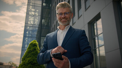 Caucasian happy euphoric mature middle-aged business man celebrate mobile win excited overjoyed...