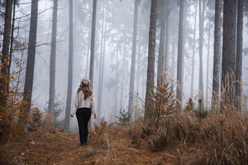 Sylwetka kobiety w lesie w porannej mgle  © meegi