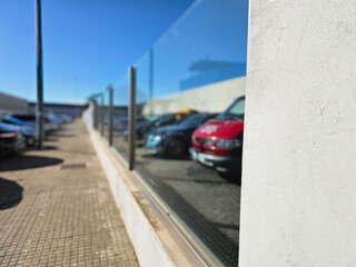 Reflections of Parked Cars on Glass Fence