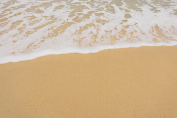 Background close-up of ocean waves rolling on the sand on the beach, with a sand texture. Sandy beach by the sea. A deserted area. Realistic seamless illustration with fine details.