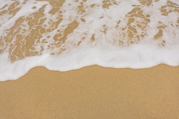 Background close-up of ocean waves rolling on the sand on the beach, with a sand texture. Sandy beach by the sea. A deserted area. Realistic seamless illustration with fine details.