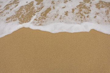 Background close-up of ocean waves rolling on the sand on the beach, with a sand texture. Sandy beach by the sea. A deserted area. Realistic seamless illustration with fine details.