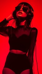 Naklejka premium Fashion pretty woman with headphones listening to music over red neon background at studio