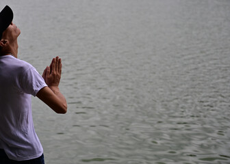 A young man prays at a lake in Hanoi-Vietnam.