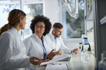 Medical experts talking while working on medical research in laboratory.