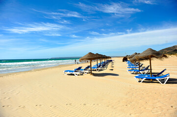 Sun loungers and parasols in Atlanterra beach of Zahara de los Atunes near Tarifa, Coast of Light Coast of Cadiz, Andalusia. One of the most famous beaches in Spain, southern Europe