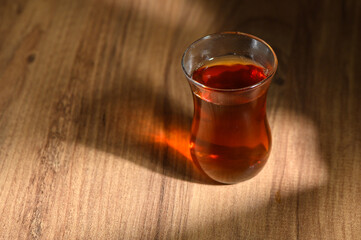 Warm tea resting on a wooden table as sunlight creates gentle shadows in a cozy setting