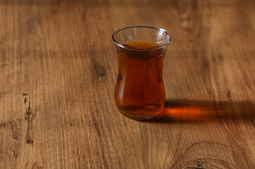 A steaming cup of aromatic tea rests on a rustic wooden table, inviting warmth with every sip in a cozy setting