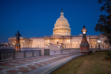 illuminated walkway leading to domed United States Capital building that is home to Senate and House of Representatives at sunrise in Washington D.C.