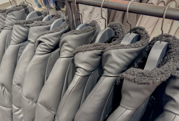Daunenjacken und Lederjacken auf einem Kleiderständer