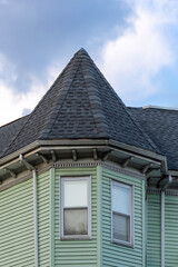 Corner turret with conical roof on a light green house in Brighton, Massachusetts, USA