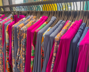 Bunte Hemden und Blusen auf einem Kleiderständer in einem Kaufhaus