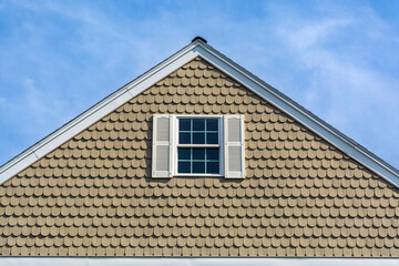 House gable end with scalloped shingle siding in Brighton, Massachusetts, USA