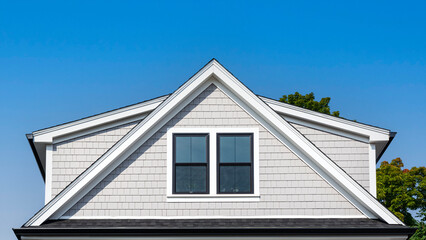 Modern gable roof with light gray shake siding on family home in Brighton, Massachusetts, USA