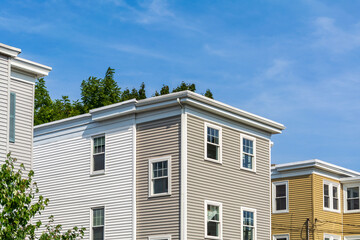 Row of residential buildings with flat roofs and vinyl siding in Brighton, Massachusetts, USA