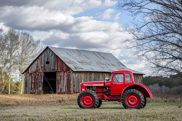 Fototapeta premium a vintage tractor parked beside an old barn, capturing rural charm.