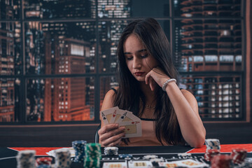  female player holding ace playing cards as win combination in poker game