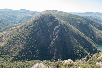Vista panorâmica da alta montanha coberta por vegetação verdejante num dia de verão e um céu claro em Portugal © LuIvDa