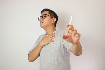Smoker holding a cigarette suffering from chronic cough, Asian man patient coughing with...
