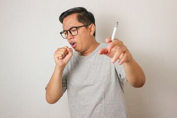 closeup Asian men coughing from smoking cigarette.