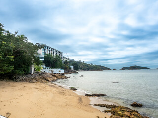 Repulse bay beach landscape view in Hong Kong, under cloudy blue sky in summer, with some unrecognized people