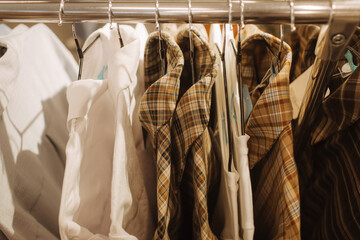 Choice of fashion clothes of different colors on hangers in a retail shop. Reduce Reuse Recycle concept. Horizontal photo