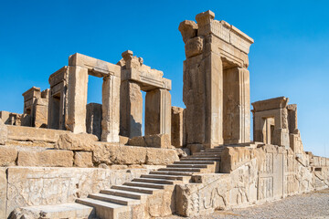Fototapeta premium Persepolis, beautiful stone archway stands tall with a blue sky, Iran