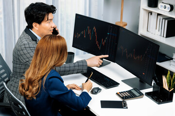 Asian business partners pointing to profit highest dynamic stock exchange data on computer screen value rate online website program. Investor showing financial on real time at modern office. Infobahn.