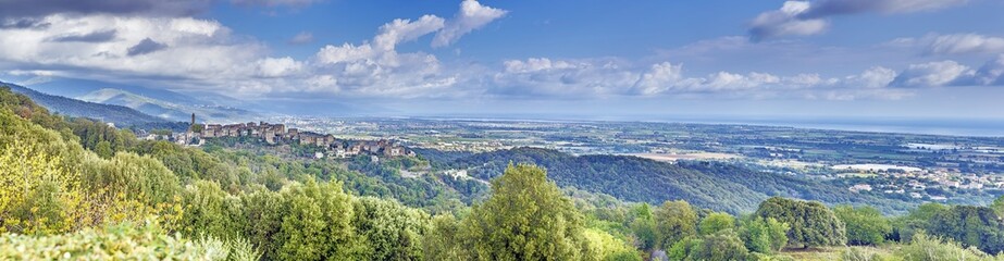 Panoramic view of a traditional Corsican mountain village with the vast eastern coastline in the distance