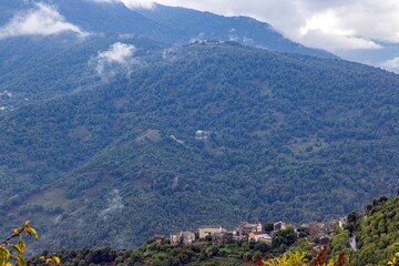 Panoramic view of a traditional Corsican mountain village with the vast eastern coastline in the distance
