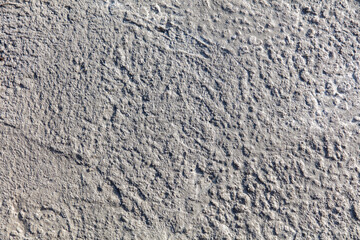 A grey and white wall with a rough texture