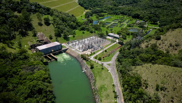 Usina Hidreletrica visto de cima com a natureza ao lado com ceu azul.