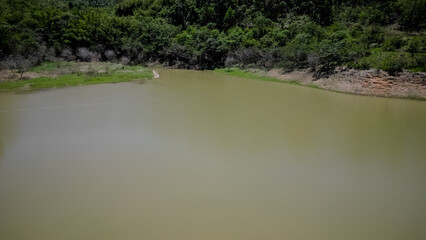 Visto de cima a represa e rodovia coma pontes altas e a natureza ao redor com lindo ceu azul.