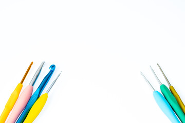  Colorful crochet hooks. Various size bright crochet hooks isolated on white background. Copy space. Top view.