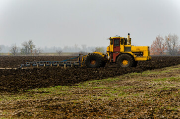 The tractor plows the land in autumn, for sowing. Image of agriculture