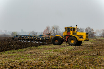 The tractor plows the land in autumn, for sowing. Image of agriculture