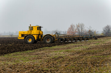 The tractor plows the land in autumn, for sowing. Image of agriculture