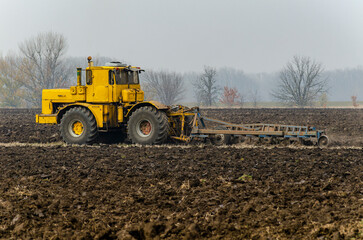 The tractor plows the land in autumn, for sowing. Image of agriculture