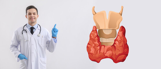 Male doctor in rubber gloves pointing at something on light background