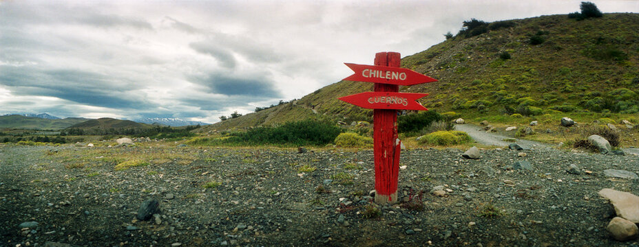 Panoramic image of an orange trail sign in the landscape of Torres Del Paine National park, Patagonia, Chile, South America..